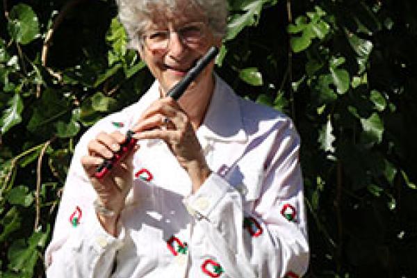 Professor Katherine Borst Jones poses with her red composite piccolo