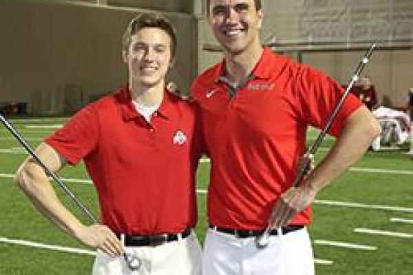 New drum majors pose with batons on the OSU practice field.