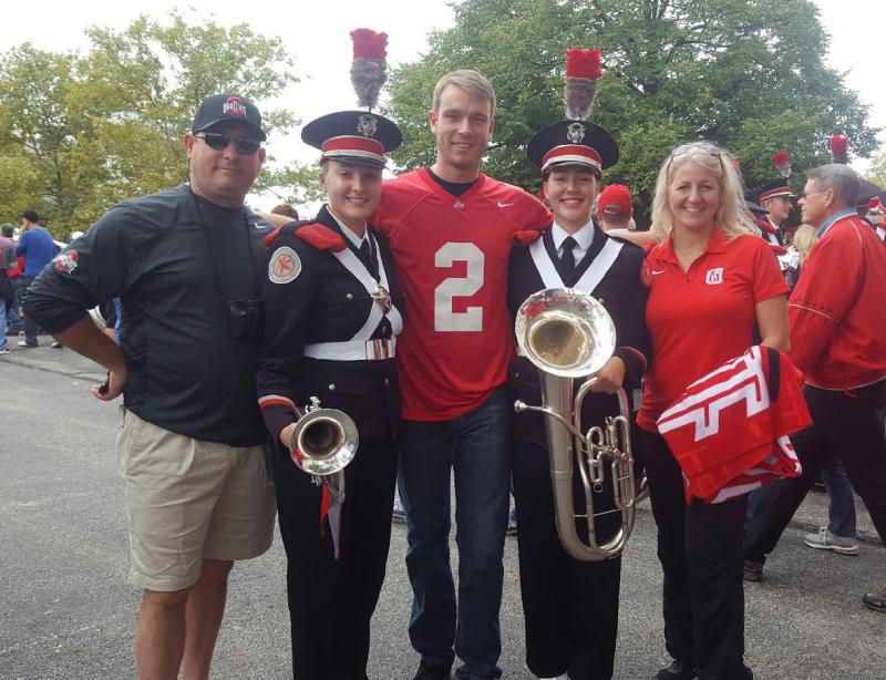 Stacy (left) and Sarah (right) pose with their family on a game day