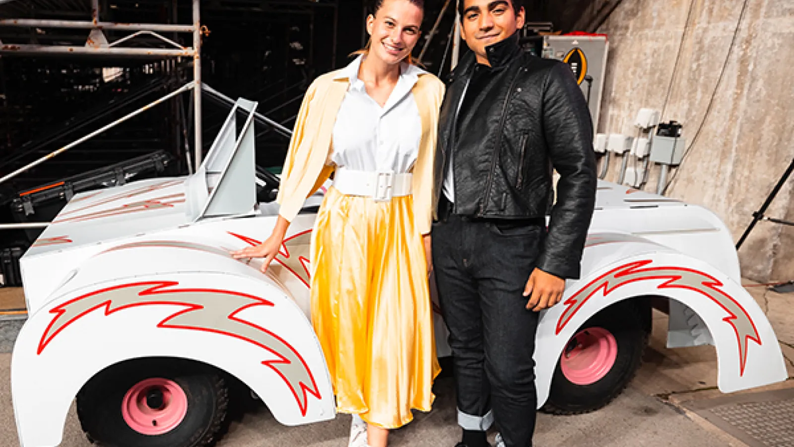 Marching band students performing in the "Grease" halftime show as Danny Zuko and Sandy Olsson