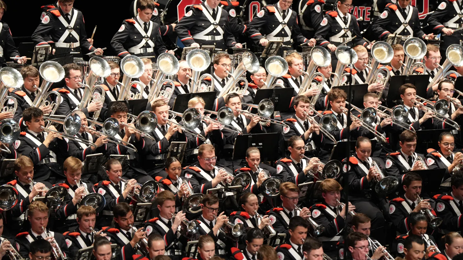 Marching Band members playing their instruments in seats.