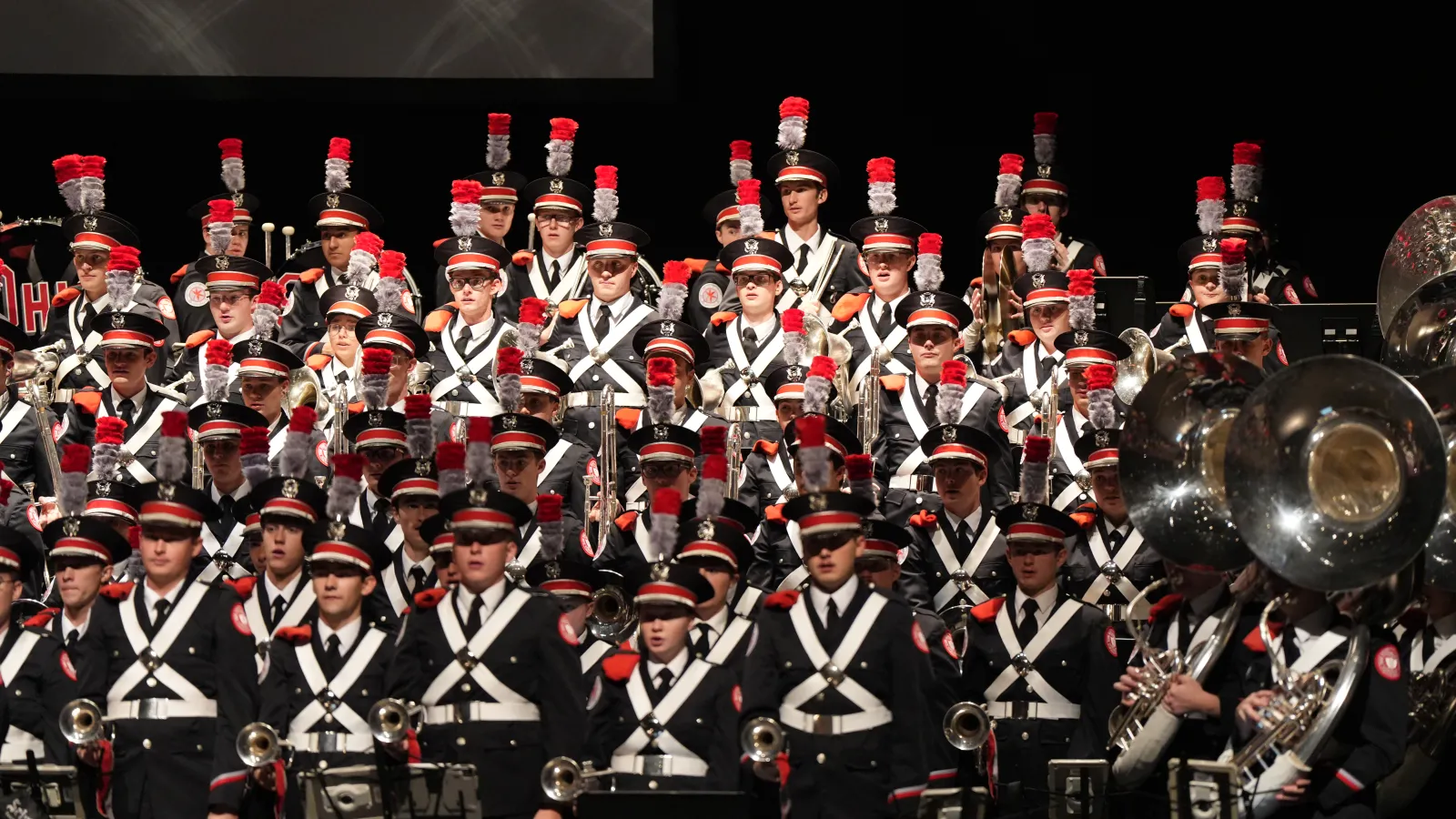 Marching band members standing and singing