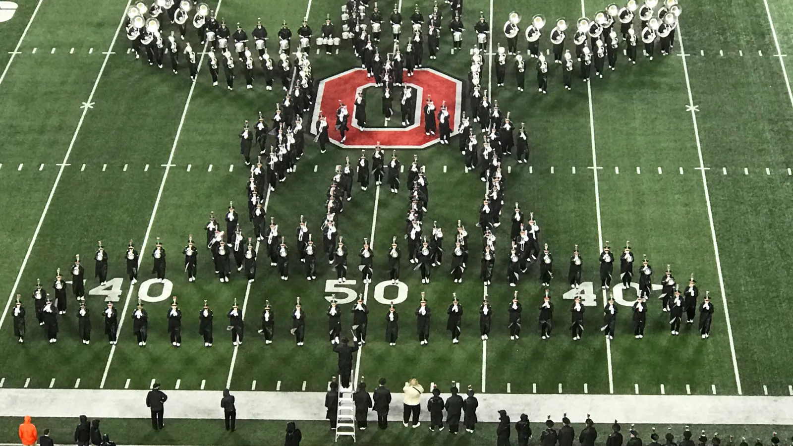 The Ohio State Marching Band forms the shape of a conductor at the OSU-Illinois halftime show