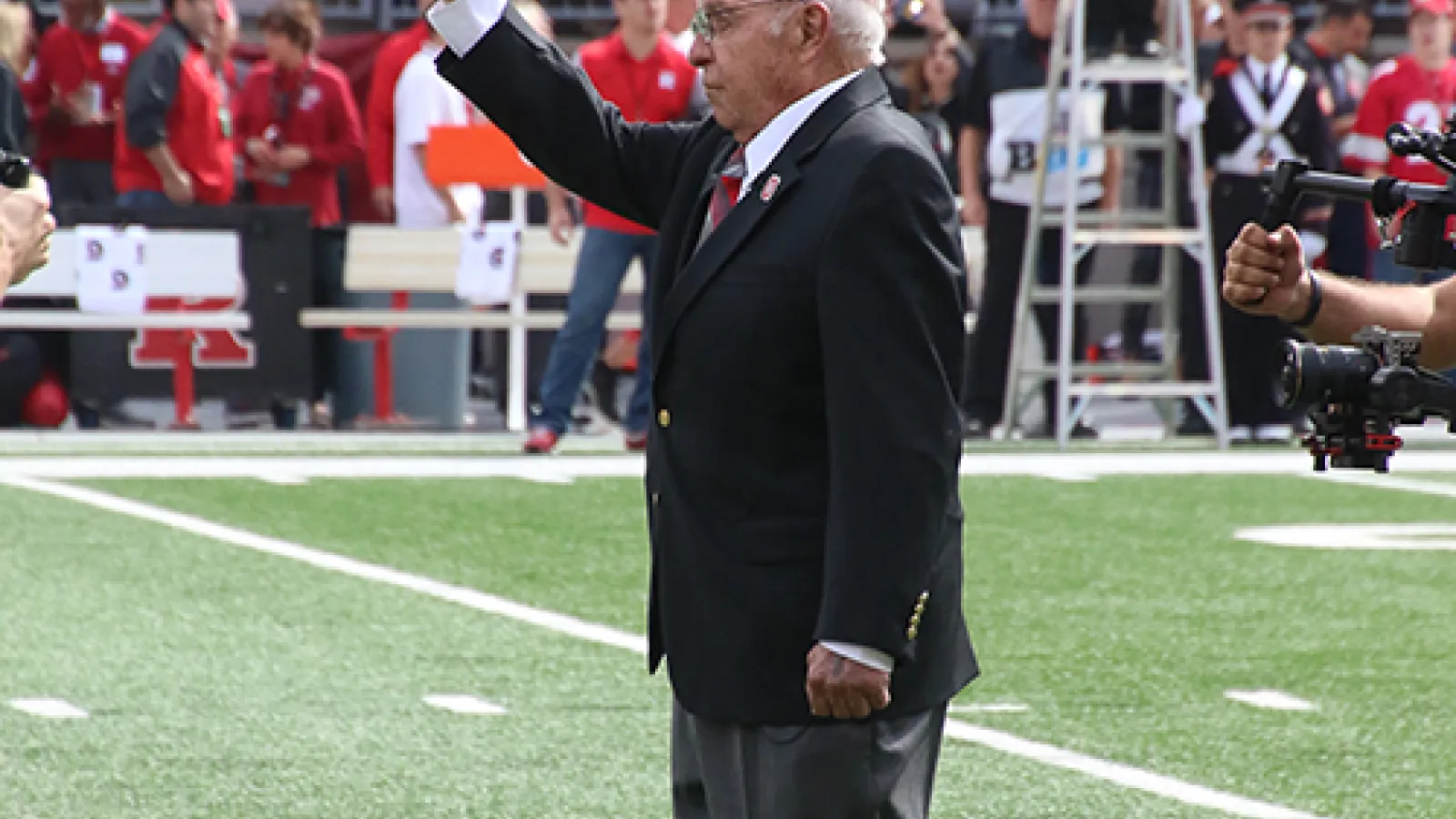 Photo of Earle Bruce dotting the "i"