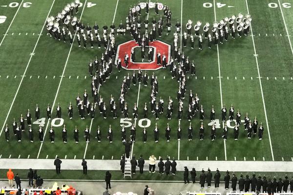 The Ohio State Marching Band forms the shape of a conductor at the OSU-Illinois halftime show