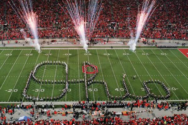 The Ohio State Marching Band forms a Script Ohio with fireworks in the background