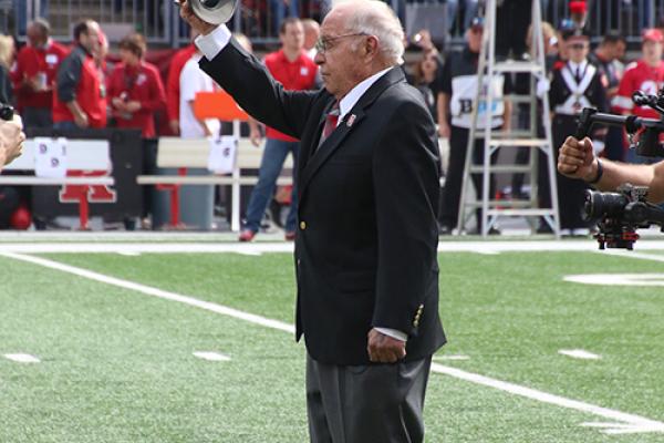 Photo of Earle Bruce dotting the "i"