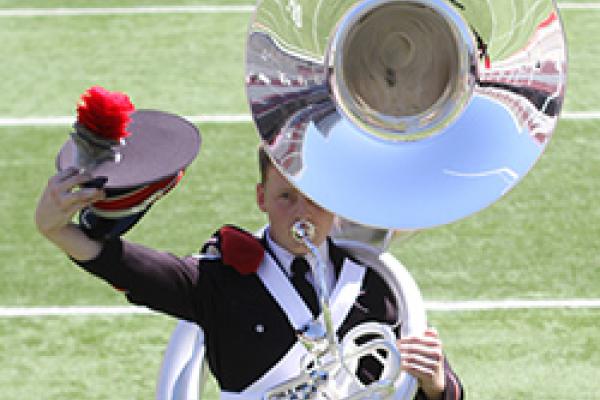 Tuba player takes his hat off to the crowd. Tuba player takes his hat off to the crowd.