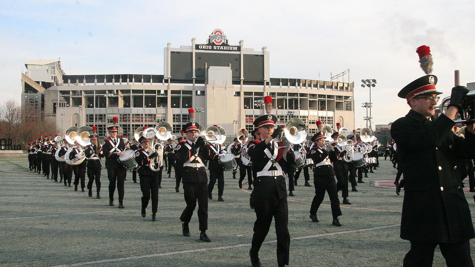 Marching band students warm up before a football game