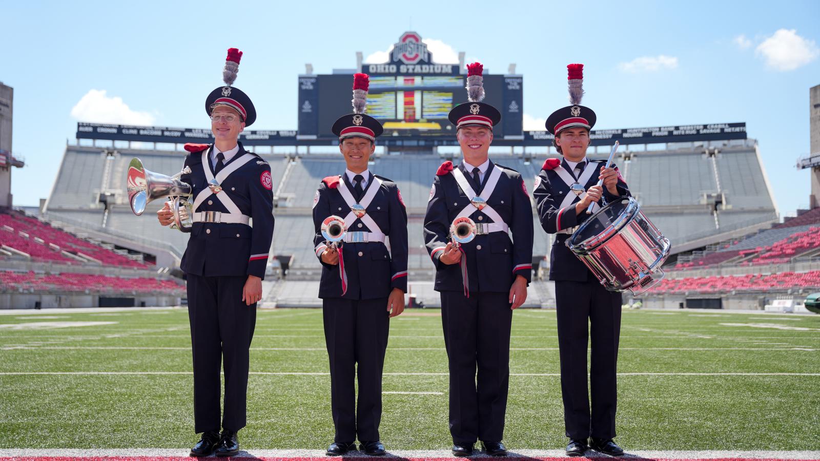 Four students wearing the new uniforms in the stadium